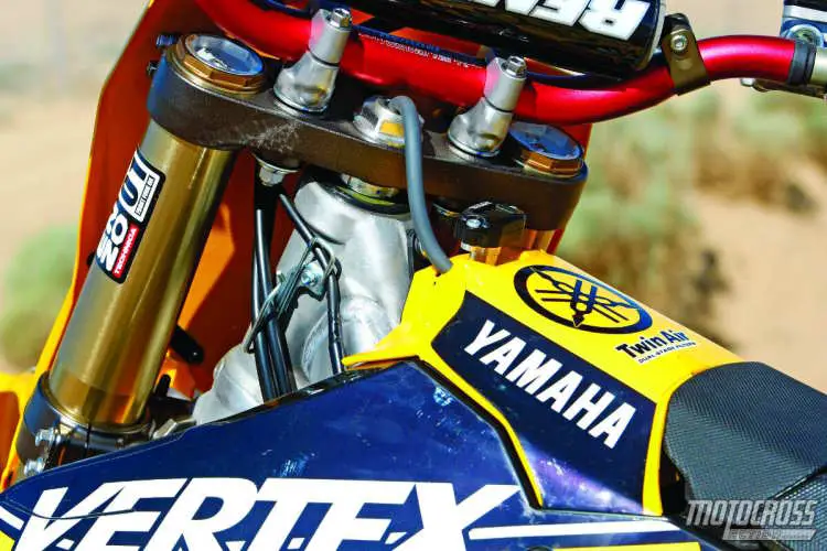 Off the showroom floor the 2014 Yamaha YZ250F is stiff. If you are fast or close to 170 pounds, you will be thrilled. But, smaller and slower riders will find it too firm. Enzo revalved the forks and shock to fit our test rider weight and speed. The coolest thing we did was to reroute the gas cap vent hose out the front of the cover.