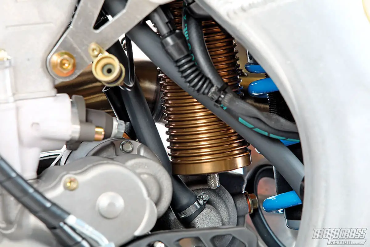 The starter motor, remote idle screw and in-house TM rear shock share space in TM’s aluminum perimeter frame.